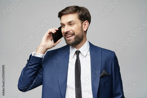 businessman talking on the phone isolated over grey background