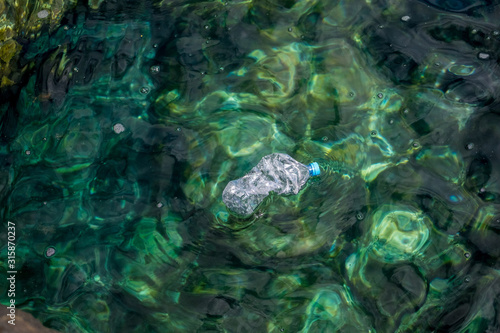 Plastics and plastic bottles at sea with very clean and crystal clear water