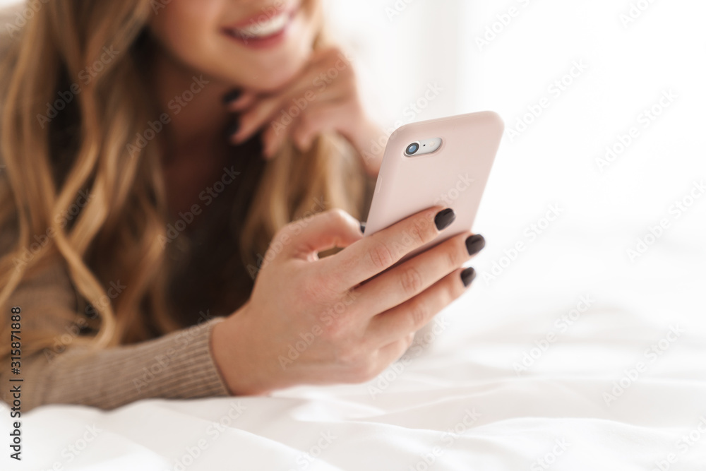 Cropped photo of young happy woman smiling and using cellphone Cropped photo of young happy woman smiling and using cellphone