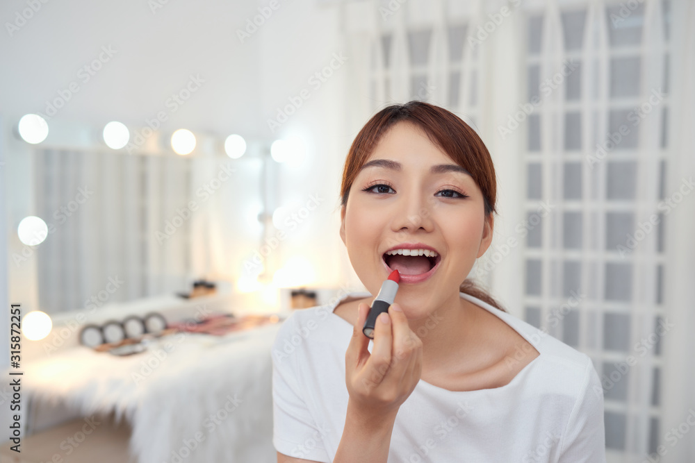 Portrait of Beautiful young Asian girl applying lipstick Portrait of Beautiful young Asian girl applying lipstick