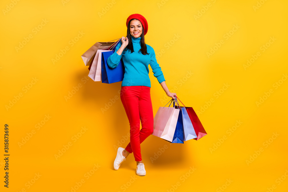 Full length body size view of her she nice attractive lovely pretty trendy cheerful cheery fashionable girl having fun carrying bargains isolated on bright vivid shine vibrant yellow color background