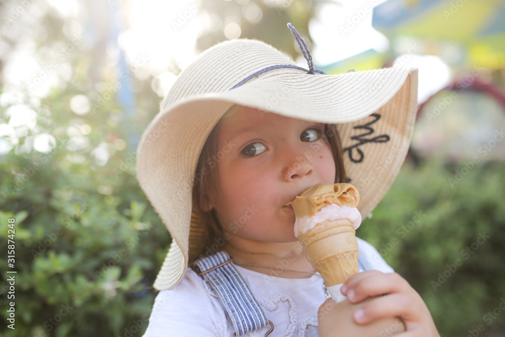 funny child in funny hat eating ice cream cone funny child in funny hat eating ice cream cone