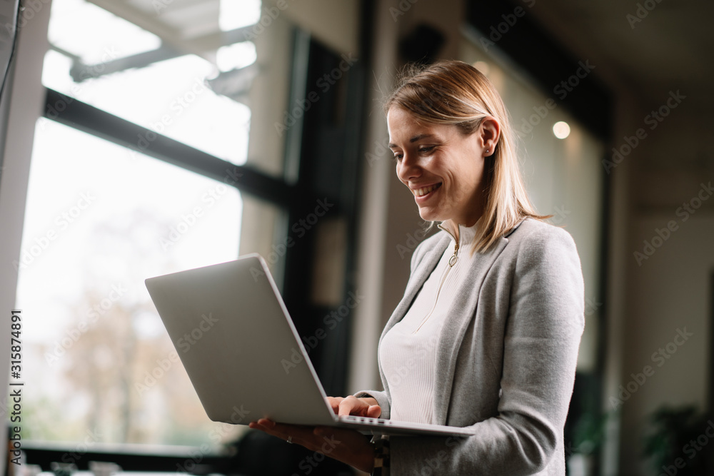 Young businesswoman in office holding laptop. Portrait of beautiful businesswoman. Young businesswoman in office holding laptop. Portrait of beautiful businesswoman.
