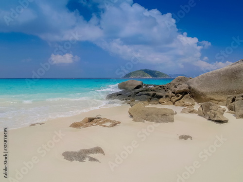 view of many arch rocks on white sand beach with blue-green sea and cloudy sky background, Similan island, Mu Ko Similan National Park, Phang Nga, southern of Thailand.