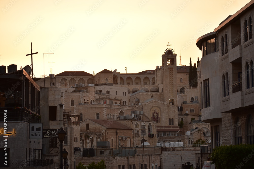 Orange sunset with a cross and church in Bethlehem