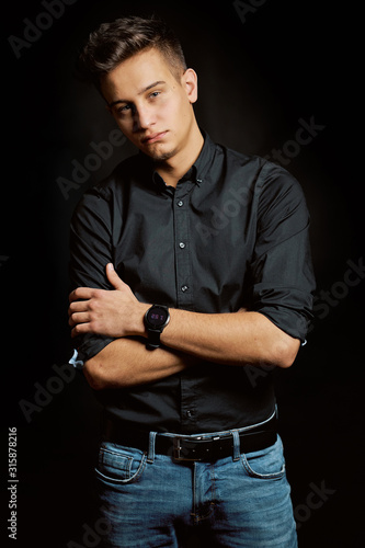 Fashion portrait of young man in shirt on black background 