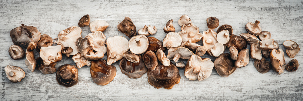 Topview panorama, lots of delicious shiitake mushrooms on wooden table - obrazy, fototapety, plakaty 
