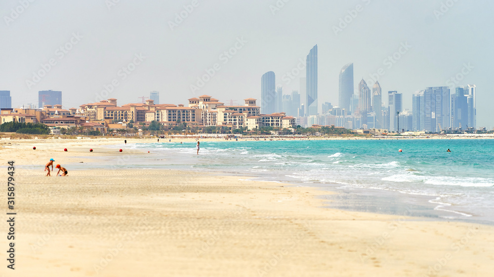 Saadiyat sandy beach with Abu Dhabi skyline at horizon