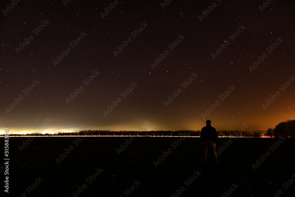 silhouette of a couple on a field on a background of the starry sky