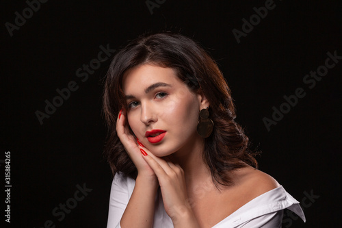 Beautiful woman with bright makeup posing isolated over black background.