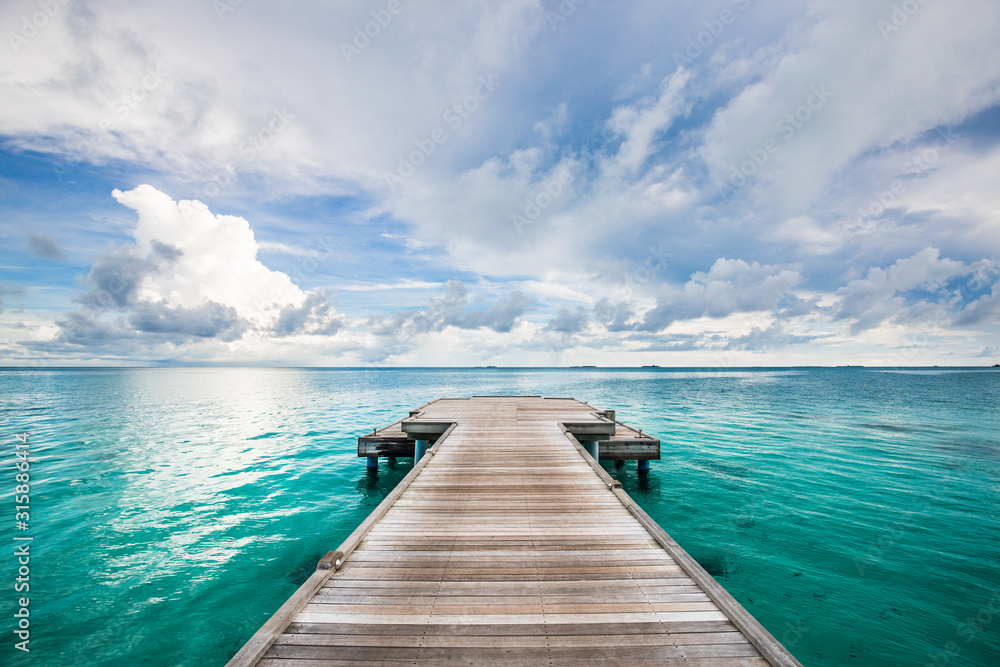 Dramatic black and white process for loneliness or inspiration. Perspective view at sea from center of wooden pier dramatic sky at daylight.