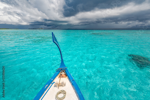 Inspirational Maldives beach design. Maldives traditional boat Dhoni and perfect blue sea with lagoon. Luxury tropical paradise concept. Exotic travel landscape, seascape in Maldives