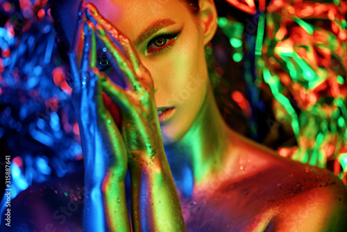 High fashion model girl portrait with colorful powder make up. Beauty woman with bright color makeup. Close-up of Vogue style lady face, Abstract colourful make-up, Art design. colored background