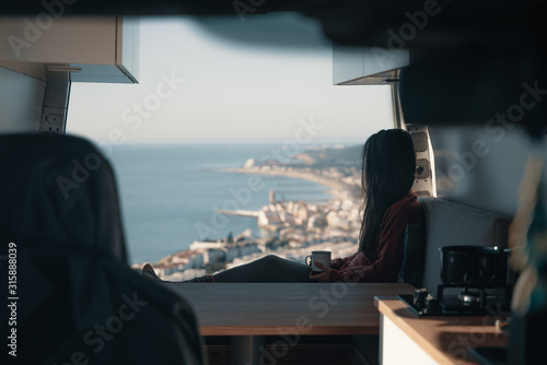 Woman sitting in vehicle looking at view
