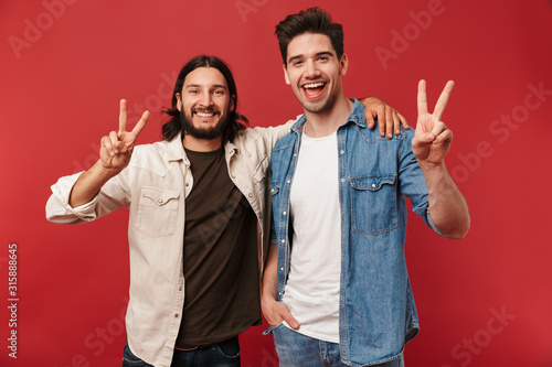 Photo of young happy guys smiling and gesturing peace sign photo