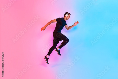 Sports man jumps. Dynamic movement. Side view, against a background of red and blue neon light