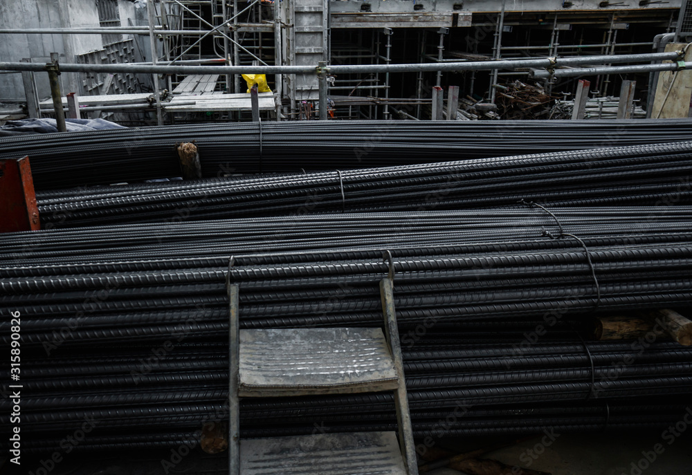 Building armature in the warehouse of metallurgical products or on construction site. Stack of heavy metal reinforcement bars with periodic profile texture. Steel construction armature. Building armature in the warehouse of metallurgical products or on construction site. Stack of heavy metal reinforcement bars with periodic profile texture. Steel construction armature.