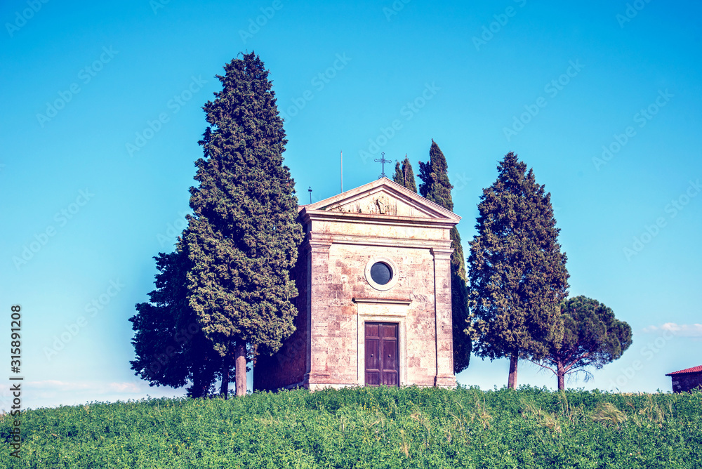 charming landscape with chapel of Madonna di Vitaleta on a sunny day in San Quirico d'Orcia (Val d'Orcia) in Tuscany, Italy. Excellent tourist places.