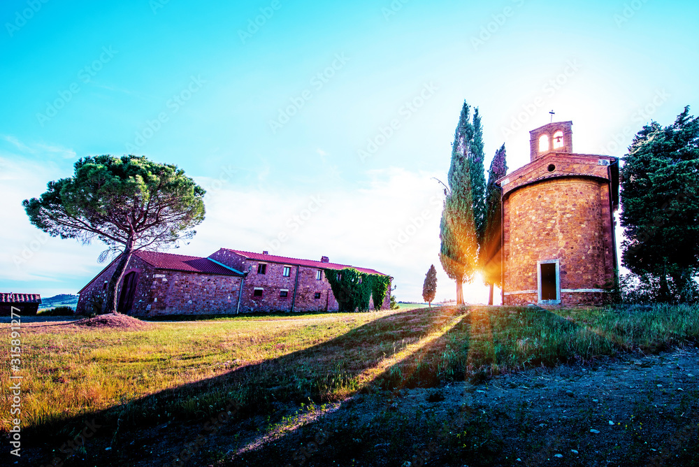Magic landscape with chapel of Madonna di Vitaleta on a sunny day in San Quirico d'Orcia (Val d'Orcia) in Tuscany, Italy. Excellent tourist places.