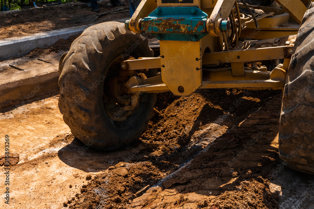 Details of grader is working on road construction. Grader industrial machine on construction of new roads. Heavy duty machinery working on highway. Construction equipment. Compaction of the road. Details of grader is working on road construction. Grader industrial machine on construction of new roads. Heavy duty machinery working on highway. Construction equipment. Compaction of the road.