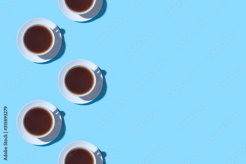 Frame of cups of black coffee or tea on a blue background. Flat lay, top view. Copy space for text. Frame of cups of black coffee or tea on a blue background. Flat lay, top view. Copy space for text.