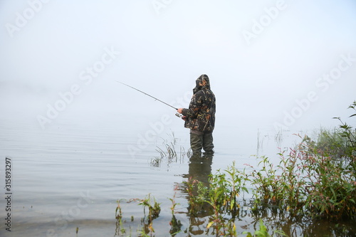 fisherman on the river in fog with copy space