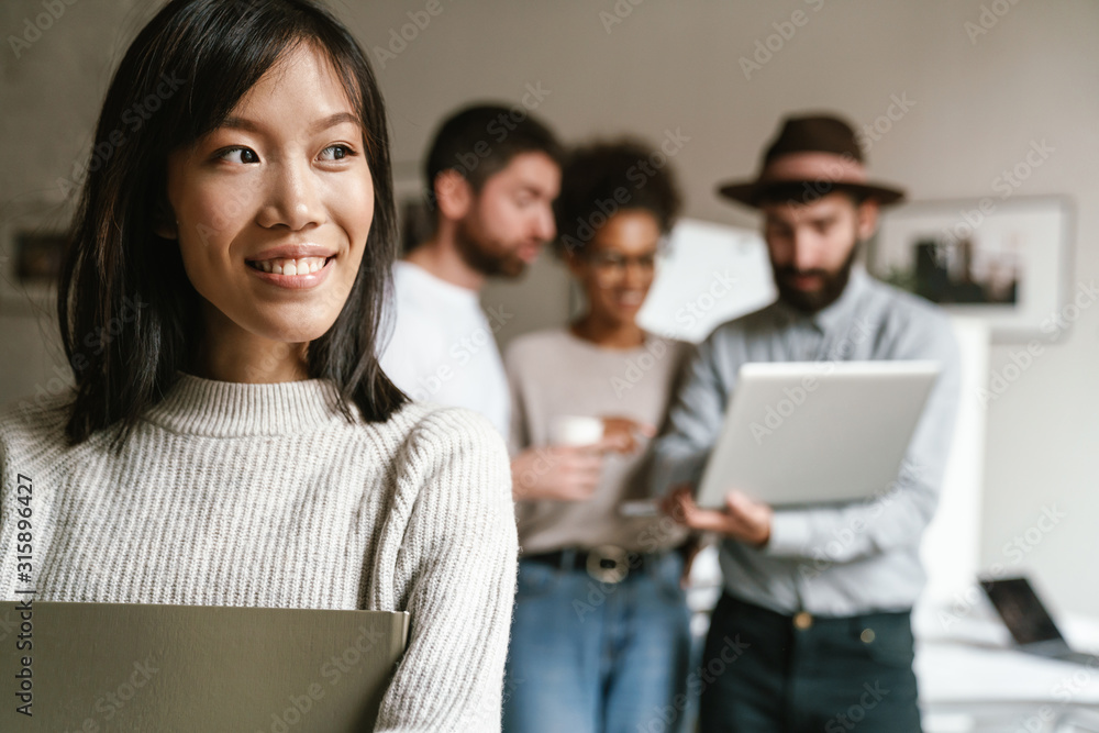 Fototapeta premium Image of multiethnic young business people working together at office