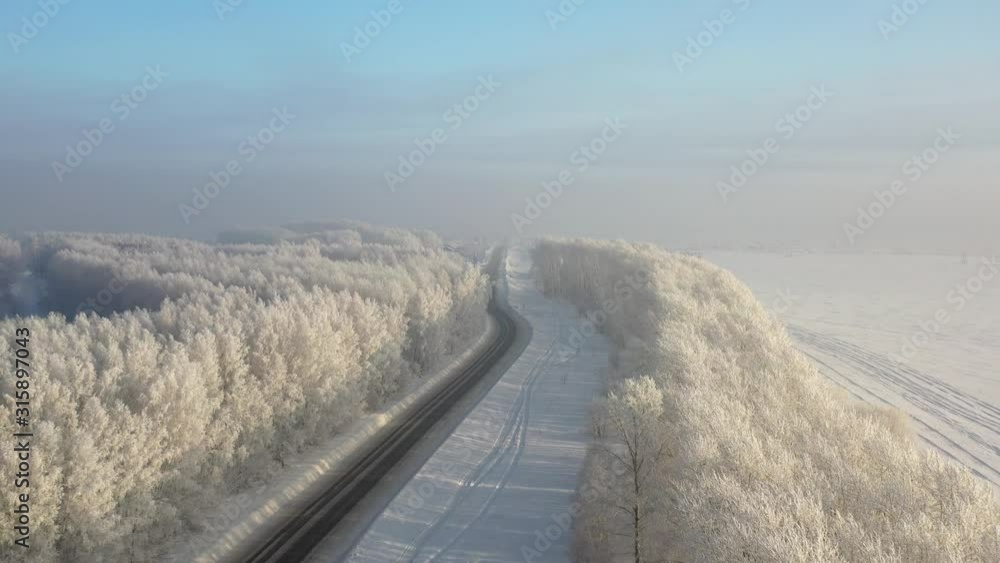 Aerial video view from drone of a Sunrise over snowy winter road. Siberia, Russia