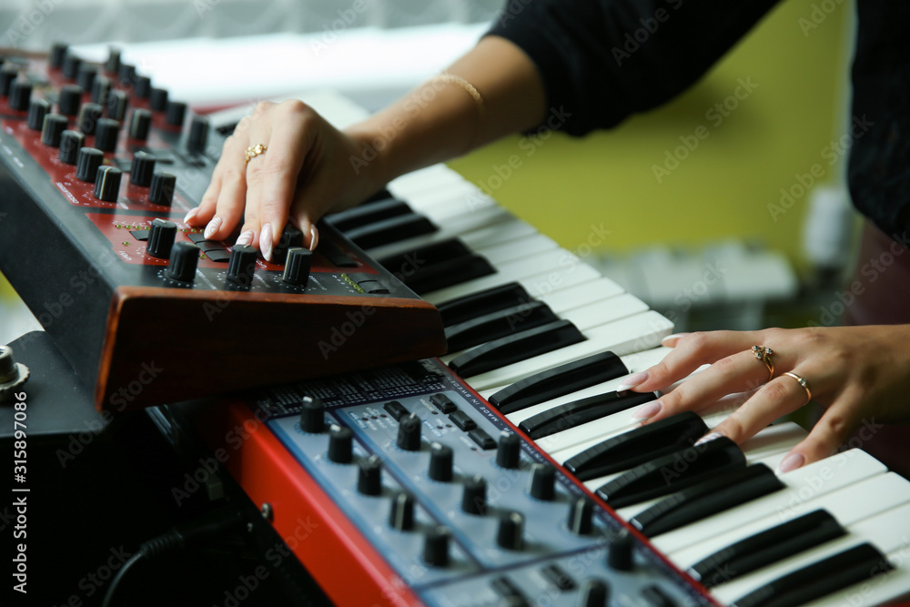 Obraz premium hands of a woman play a synthesizer close up
