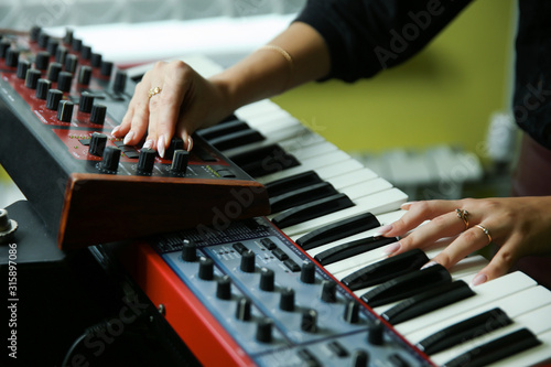 hands of a woman play a synthesizer close up photo