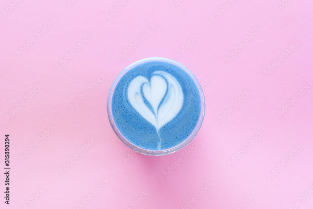 Blue matcha latte with rosetta art on pink background Blue matcha latte with rosetta art on pink background