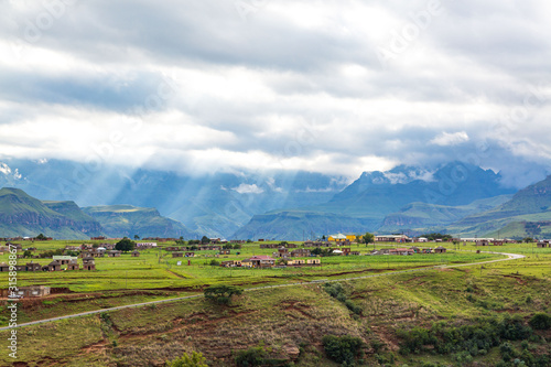Wallpaper Mural Village in the mountains of Maloti Drakensberg Park with sunbeams breaking through the clouds, South Africa Torontodigital.ca