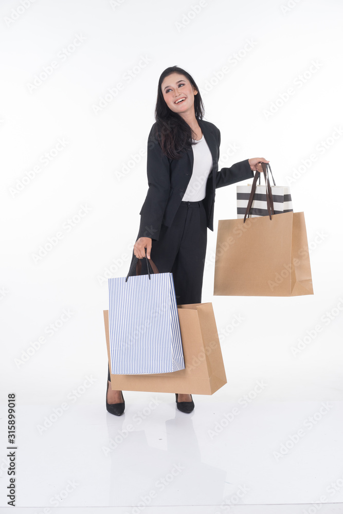 A beautiful Asian woman wearing officewear poses with shopping bags isolated on white background. Full body suitable for image cut out and manipulation works for business and commerce concepts. A beautiful Asian woman wearing officewear poses with shopping bags isolated on white background. Full body suitable for image cut out and manipulation works for business and commerce concepts.