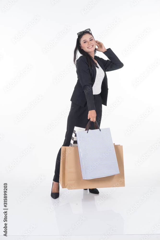 A beautiful Asian woman wearing officewear poses with shopping bags isolated on white background. Full body suitable for image cut out and manipulation works for business and commerce concepts. A beautiful Asian woman wearing officewear poses with shopping bags isolated on white background. Full body suitable for image cut out and manipulation works for business and commerce concepts.