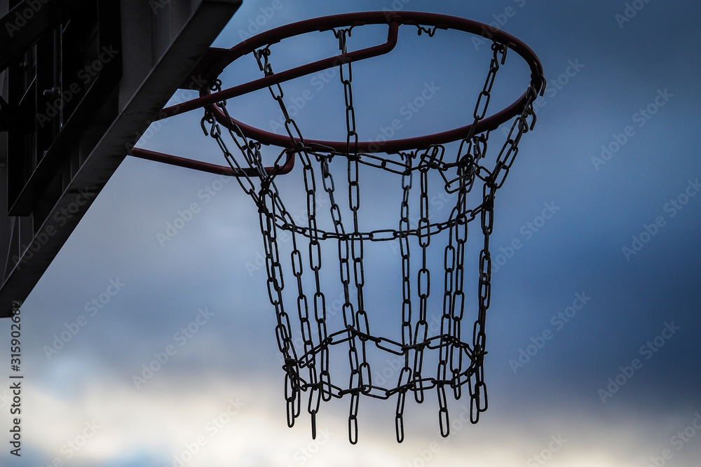 Streetball basketball basket with chains in the place of net, on a dark day Streetball basketball basket with chains in the place of net, on a dark day