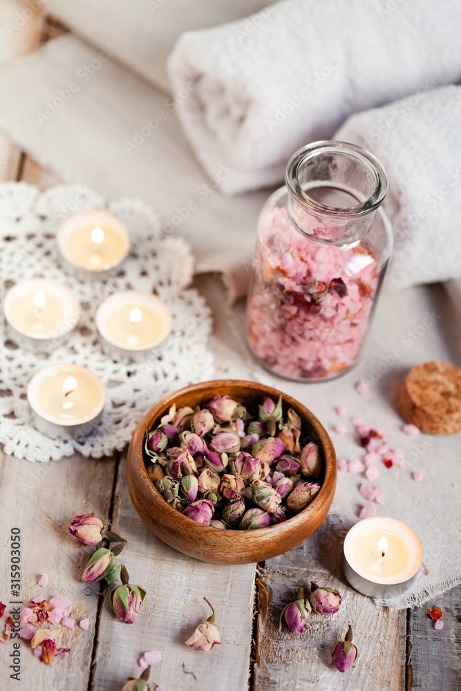 Concept of spa treatment with roses. Dry flowers in a bowl, crystals of sea pink salt in bottle, candles as decor. Atmosphere of relax, anti-stress and detox prosedure. Luxury lifestyle. 