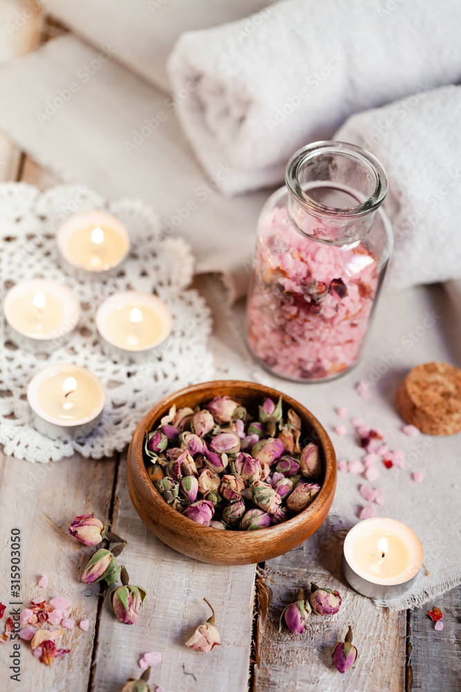 Concept of spa treatment with roses. Dry flowers in a bowl, crystals of sea pink salt in bottle, candles as decor. Atmosphere of relax, anti-stress and detox prosedure. Luxury lifestyle. Concept of spa treatment with roses. Dry flowers in a bowl, crystals of sea pink salt in bottle, candles as decor. Atmosphere of relax, anti-stress and detox prosedure. Luxury lifestyle.