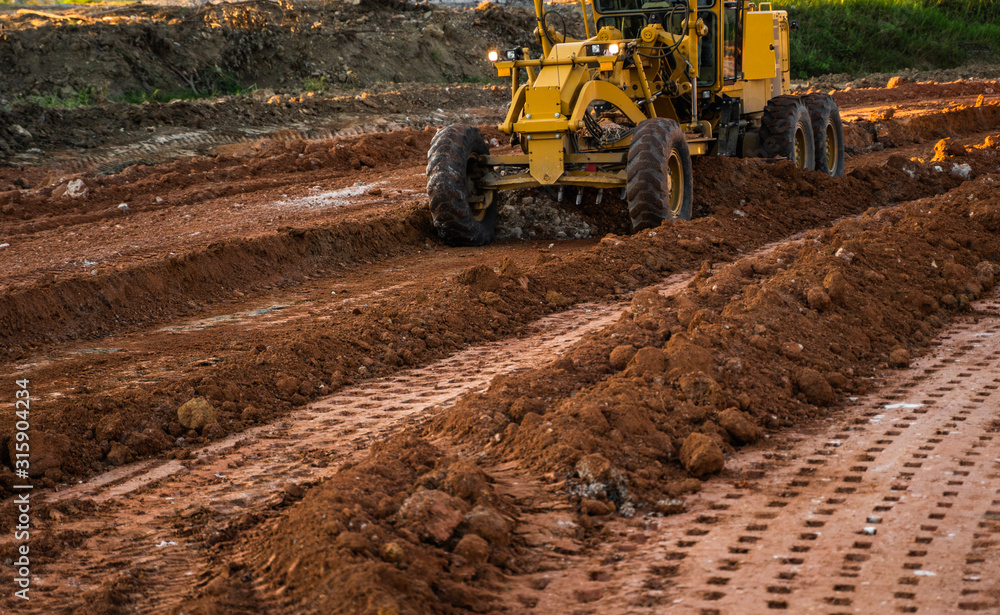 Grader is working on road construction. Grader industrial machine on construction of new roads. Heavy duty machinery working on highway. Construction equipment. Compaction of the road. Grader is working on road construction. Grader industrial machine on construction of new roads. Heavy duty machinery working on highway. Construction equipment. Compaction of the road.