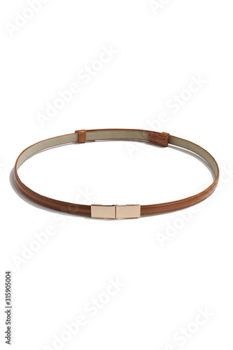 Subject shot of a thin belt made of brown patent leather and decorated with a golden buckle made as two right angled parts. The stylish belt is isolated on the white background.