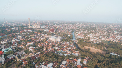 Residential neighborhood subdivision skyline Aerial shot. Top view of house Village from Drone capture. Top-down aerial drone image of a suburb in the midst of summer. Midtown of Indonesia. © Ihsan