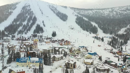 Mounting skiing resort. People skiing and snowboarding from the mountain.Beautiful view from above