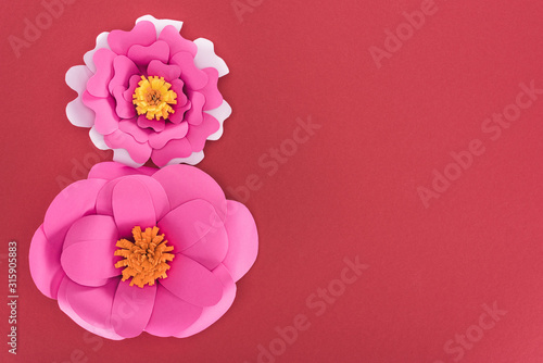 top view of paper pink paper flowers isolated on red