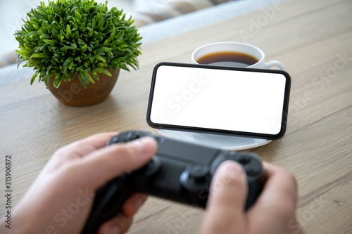 male hands holding joystick background of phone with isolated screen photo