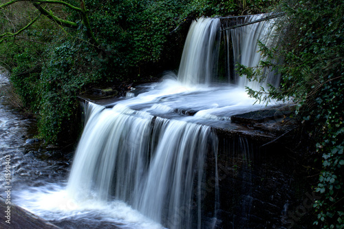 Fototapeta Naklejka Na Ścianę i Meble -  A waterfall on the walk beside Spring Canal in Skipton is a popular attraction for walkers making their way to Castle Woods