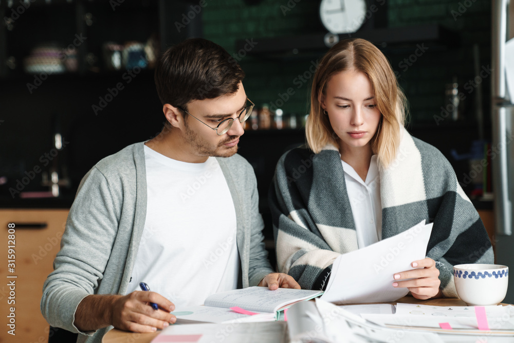 Image of happy young businesslike man and woman doing paperwork in cafe