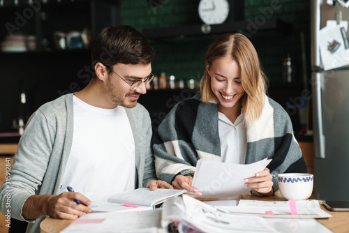 Image of happy young businesslike man and woman doing paperwork in cafe © Drobot Dean
