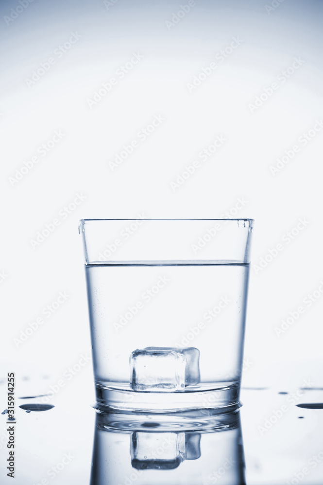 Clear mineral water splashes in a glass with ice. Clear mineral water splashes in a glass with ice.