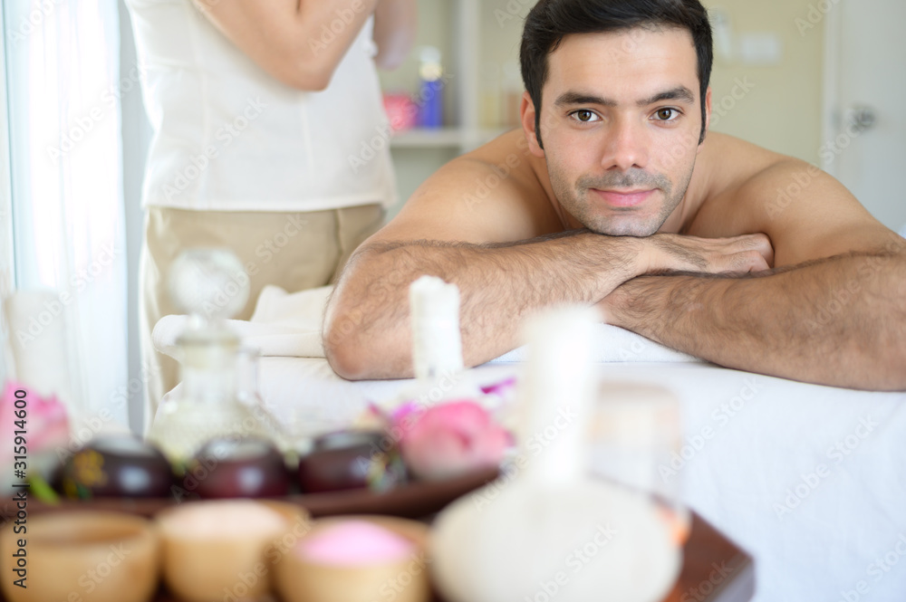 Young man is feeling comfortable and relaxed with a massage at the spa.