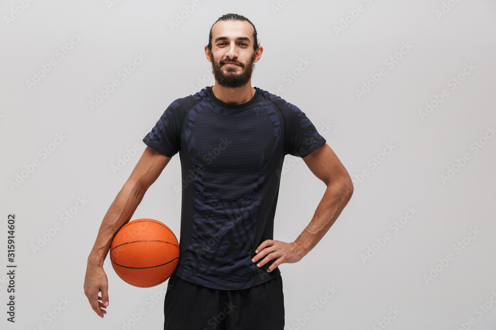 Image of young pleased man posing with basketball and smiling Image of young pleased man posing with basketball and smiling