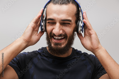 Image of sportsman smiling while listening to music with headphones
